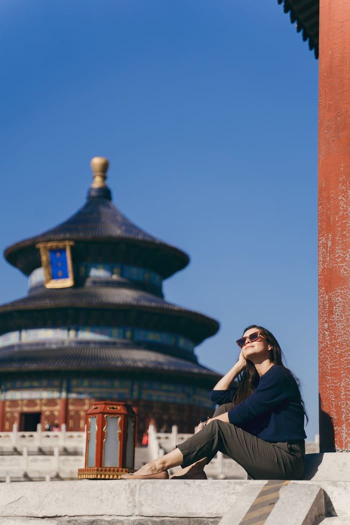 Mujer sentada frente a un templo en China